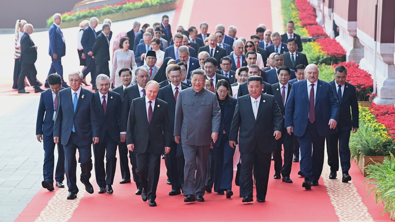 Group of people walk behind Chinese, Russian and DPRK leaders