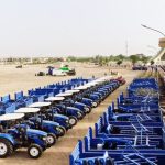 Lines of blue tractors, part of the agricultural machinery being distributed to farmers by the government