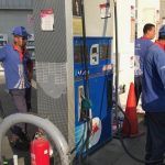 Workers fuel vehicles at a gas station in Cairo, Egyp