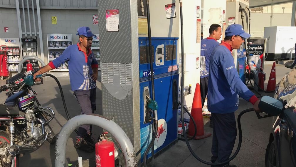 Workers fuel vehicles at a gas station in Cairo, Egyp