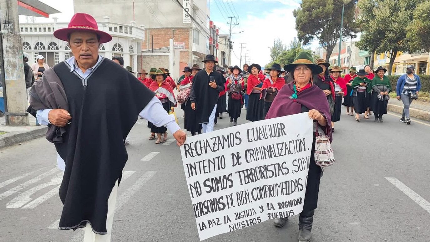 Indigenous protestors in Ambato, Ecuador holding a sign