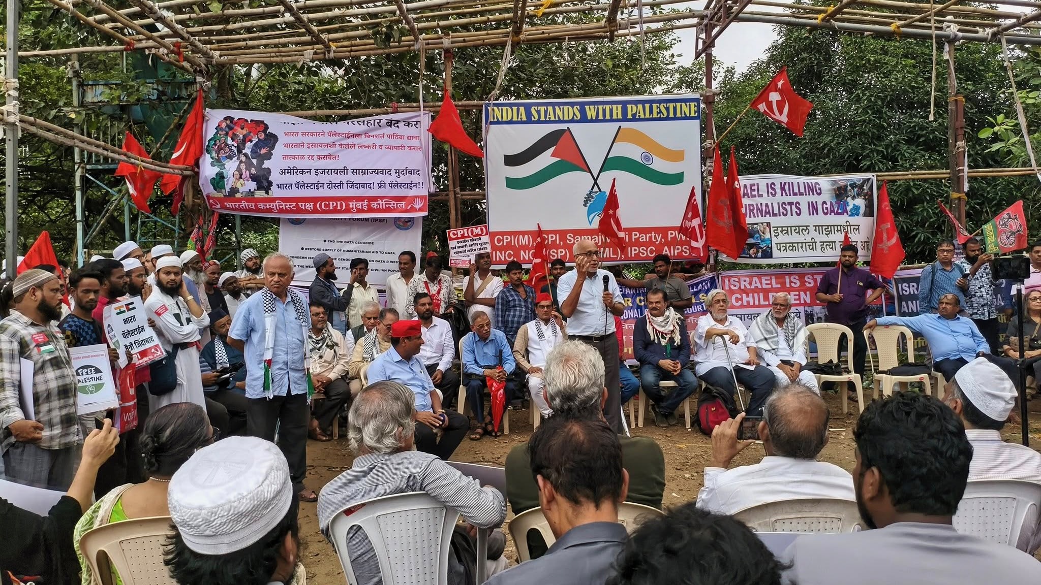 Speakers at Palestine protest in Mumbai stand in front of Palestine solidarity banners