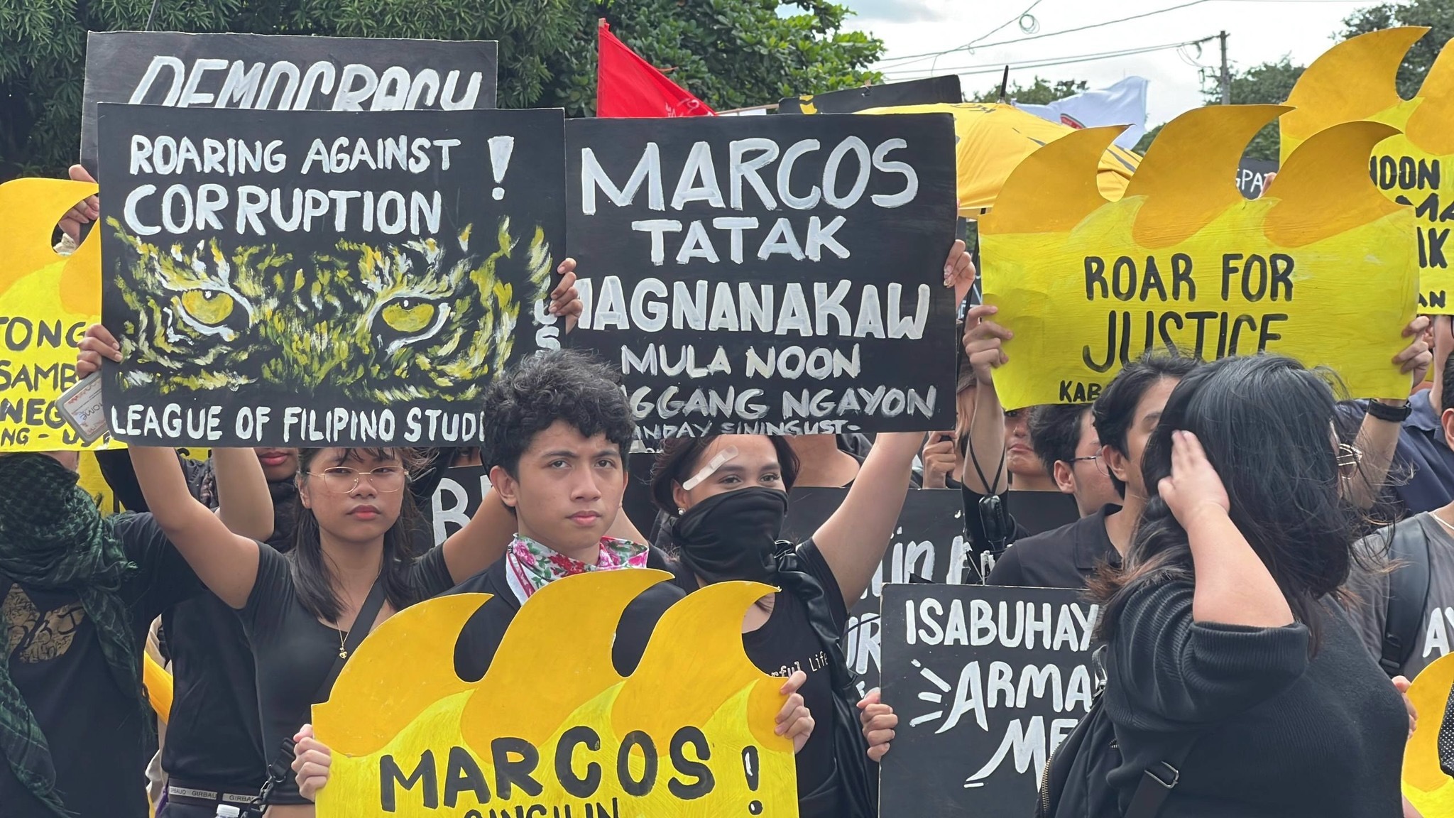 Youth protestors in Philippines raise signs against corruption