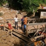 People repair a collapsed bridge affected by Cyclone Ditwah in Badulla District, Sri Lanka, Dec. 13, 2025.