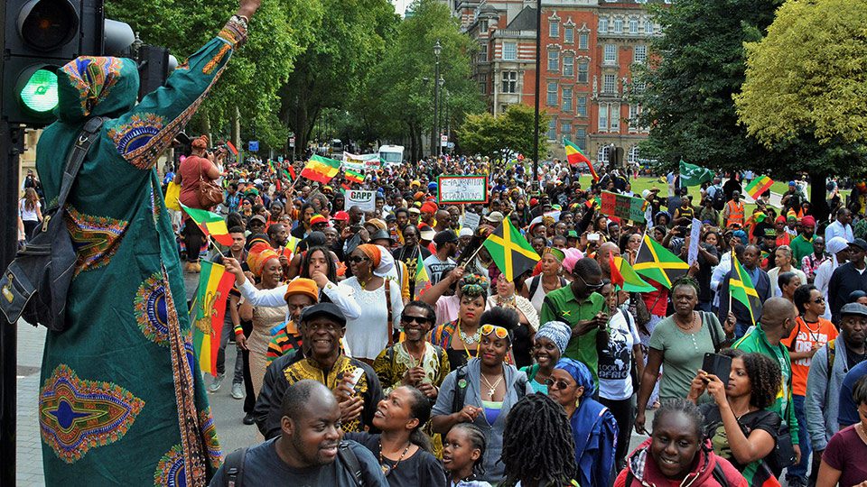 Protestors march in London waving Jamaican and Ethiopian flags
