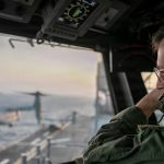 A naval officer aboard USS Tripoli oversees flight operations from the control tower as the amphibious assault ship sails in the Arabian Sea.