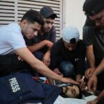Palestinians stand over the body of Ahmed Wishah
