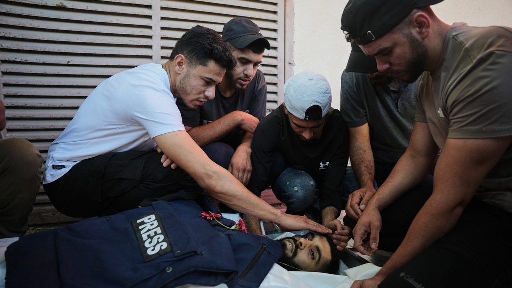 Palestinians stand over the body of Ahmed Wishah