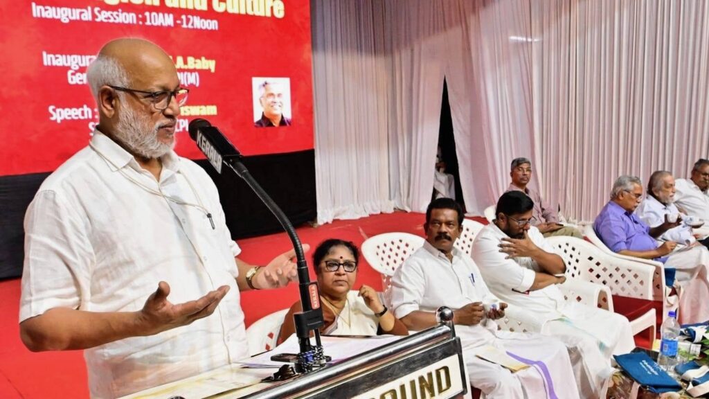 Indian left leaders speak at podium in front of red background at seminar