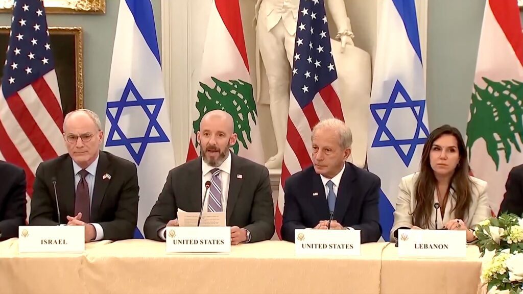 Israeli, Lebanese, and US representatives sit at table with their flags in the background