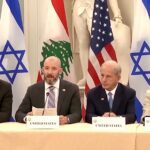 Israeli, Lebanese, and US representatives sit at table with their flags in the background