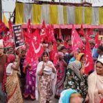 Indian leftists and organized workers gather and hold hammer and sickle flags in a village in West Bengal