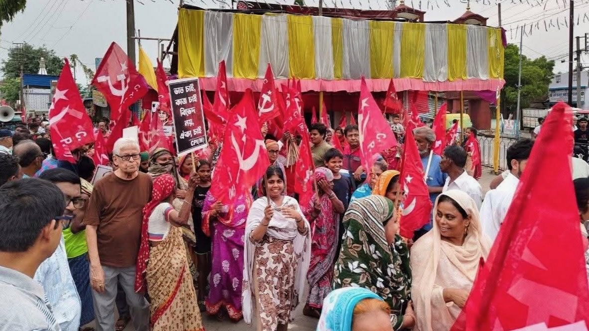 Indian leftists and organized workers gather and hold hammer and sickle flags in a village in West Bengal