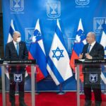 Prime Minister of Slovenia Janez Janša stands in front of a glass podium alongside Israeli Prime Minister Benjamin Netanyahu