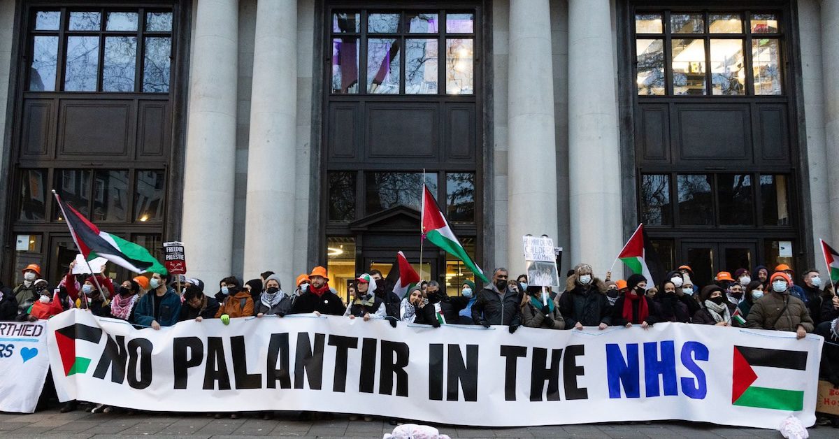 Activists raise banner that reads "No Palantir in the NHS!"
