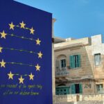 Art piece of EU symbol with barbed wire between the stars and a quote