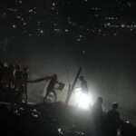 Rescue workers at night on top of rubble of a collapsed building in Venezuela