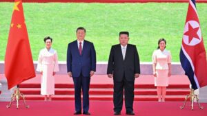 Xi Jinping, general secretary of the Communist Party of China Central Committee and Chinese president stands next to Kim Jong Un, general secretary of the Workers' Party of Korea