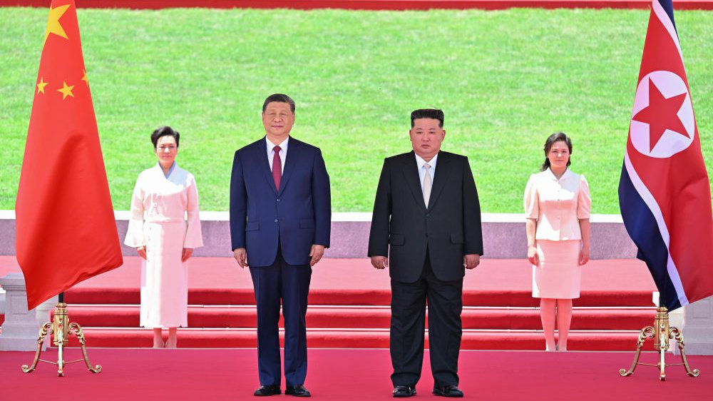 Xi Jinping, general secretary of the Communist Party of China Central Committee and Chinese president stands next to Kim Jong Un, general secretary of the Workers' Party of Korea