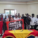 Ugandan communists pose with banners of Marxist revolutionaries